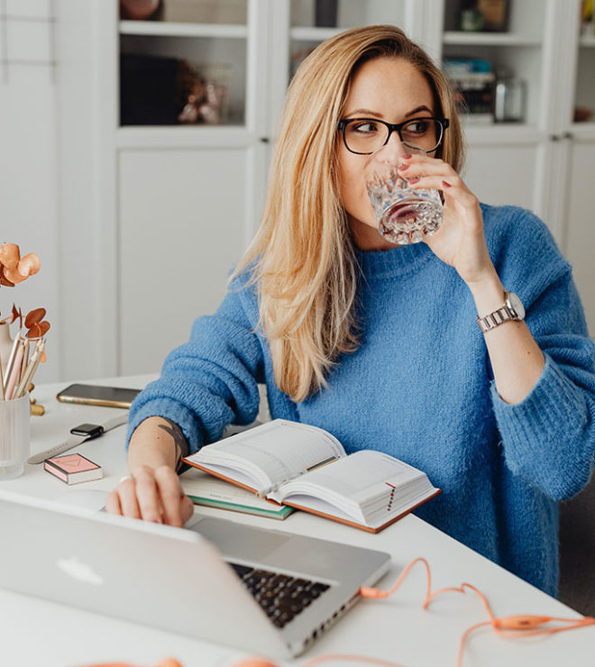 digital marketing for financial services girl in the office working at the laptop and drinking water from a glass