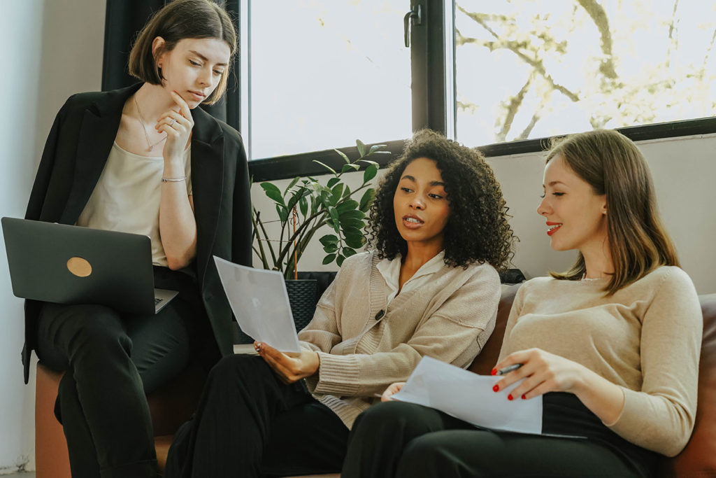 internet marketing company girls in the office with laptops discussing