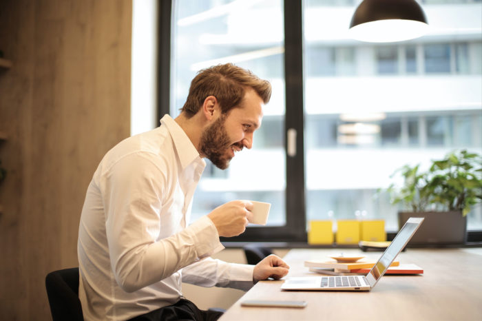 marketing automation service provider man with coffee and laptop in the office