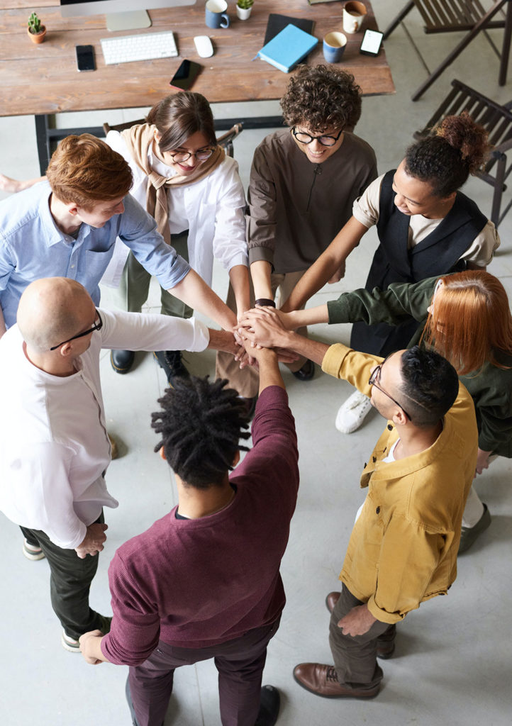 team of experts holding hands together