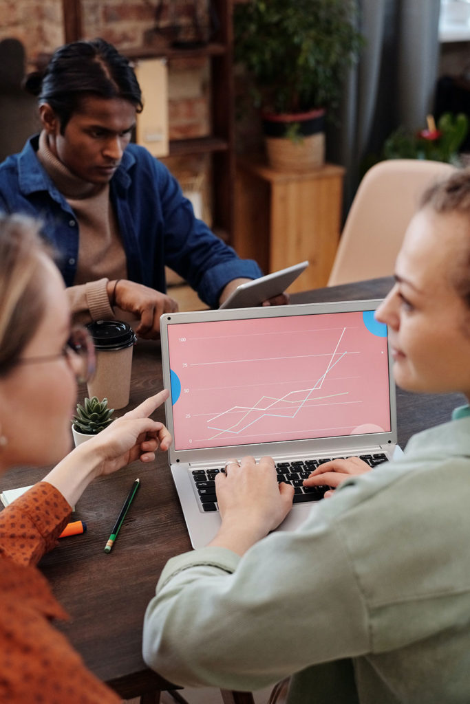 experts discussing a marketing results diagram displayed on the laptop screen in the office