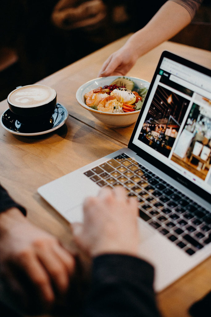 man browsing directory websites at the laptop and drinking coffee