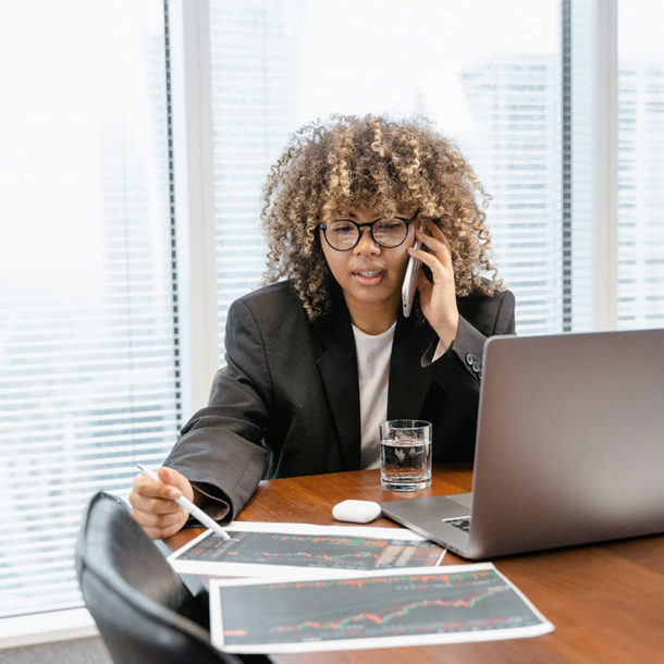 seo expert analysing results of optimization and talking by phone in the office with laptop