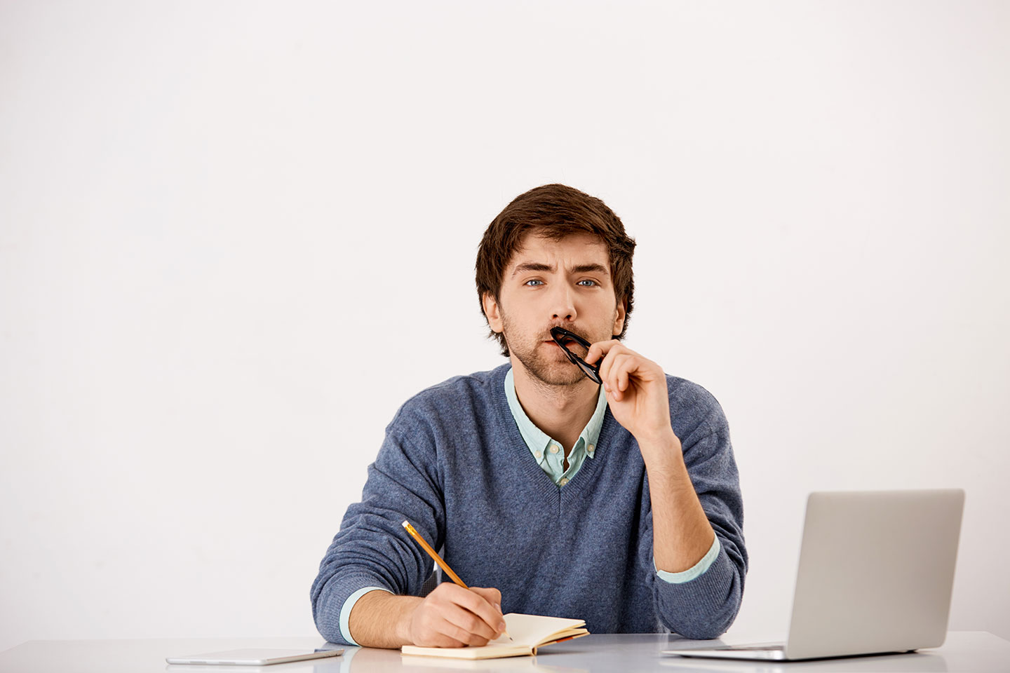 thoughtful man sitting office desk writing trying think up idea